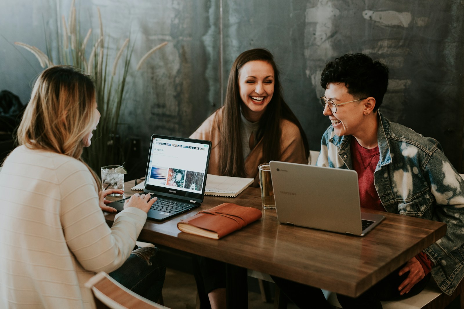 Small group collaborating around a laptop in a bright studio